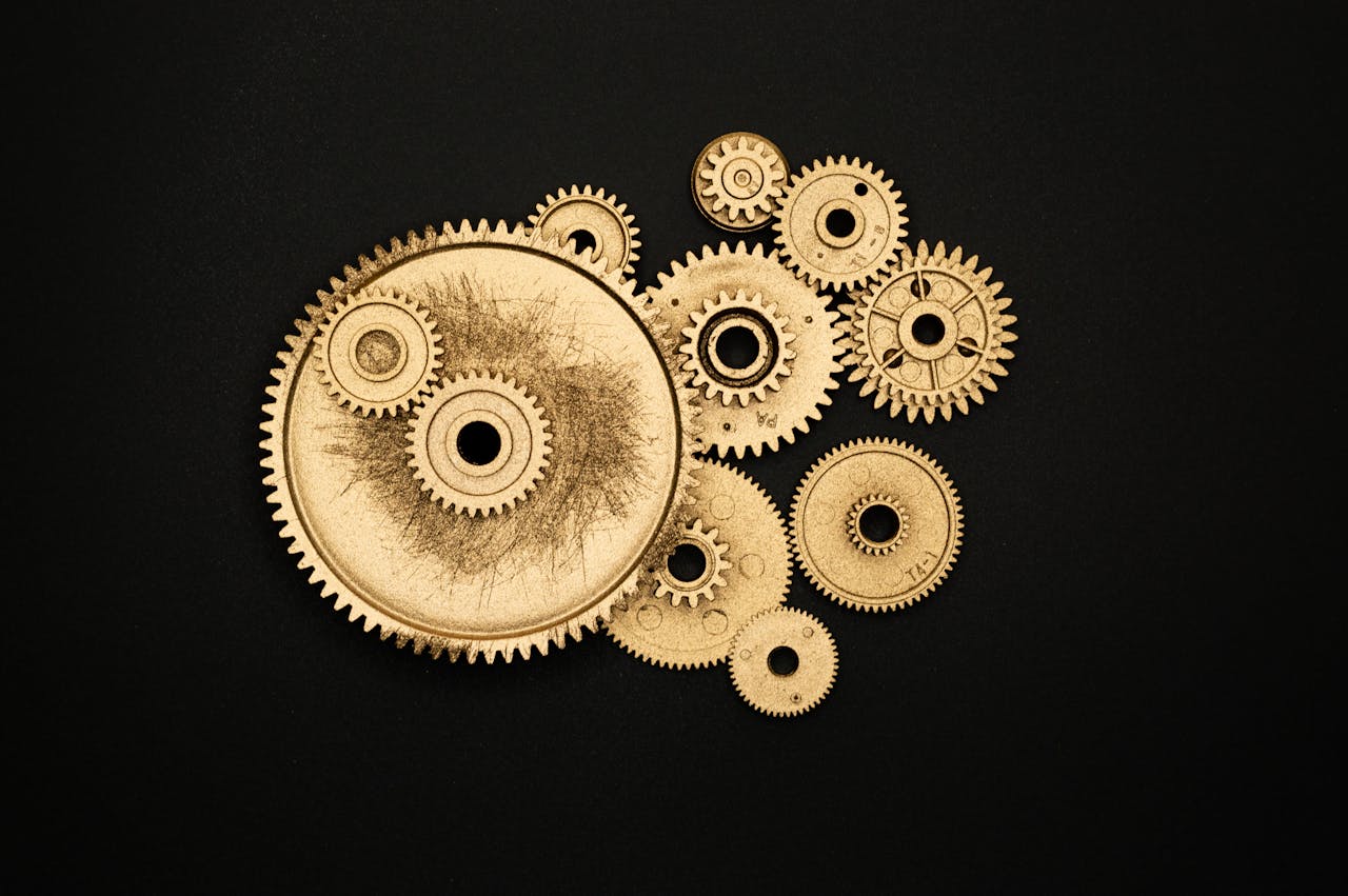 Close-up of golden cogs and gears arranged on a black background showcasing industrial precision.